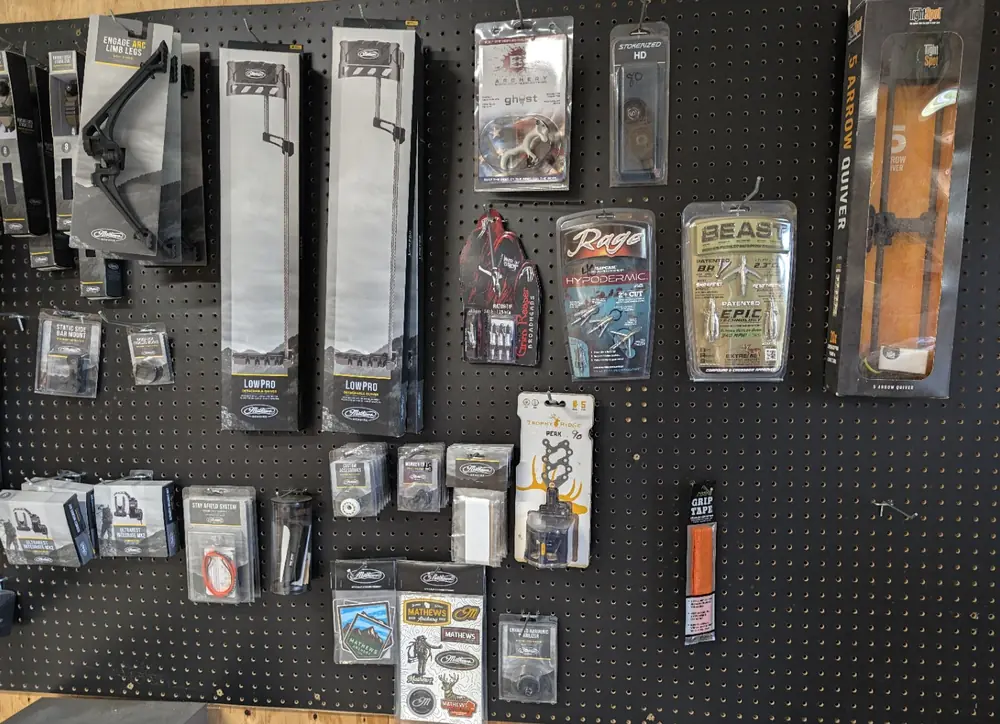 Sights, quivers, broadheads, and Mathews accessories displayed inside Black Flag Archery
